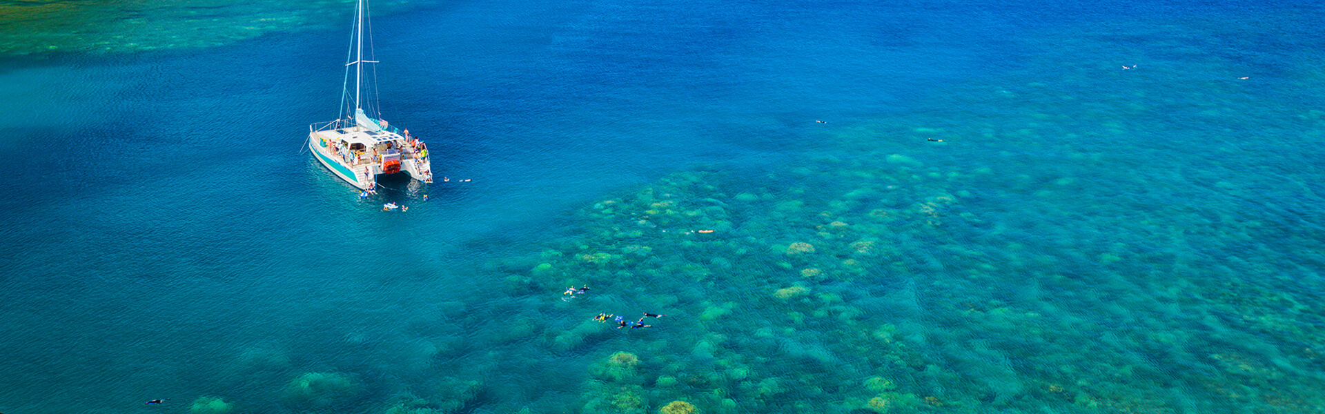 Aerial view of catamaran and snorkelers in bay