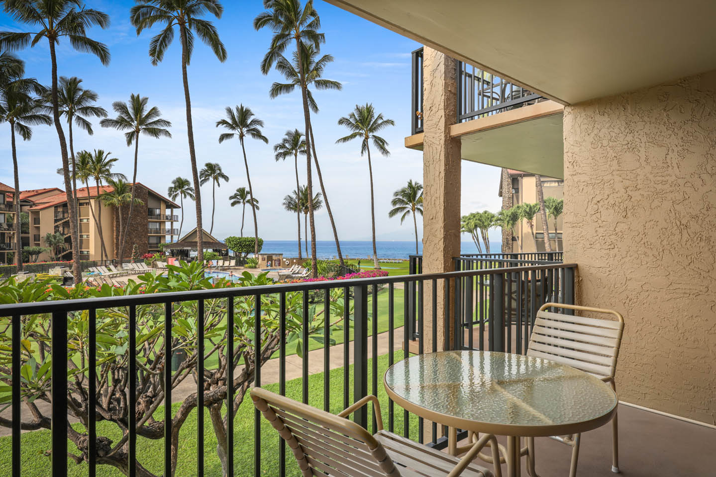Studio Ocean View lanai with seating area overlooking the grounds and the ocean  