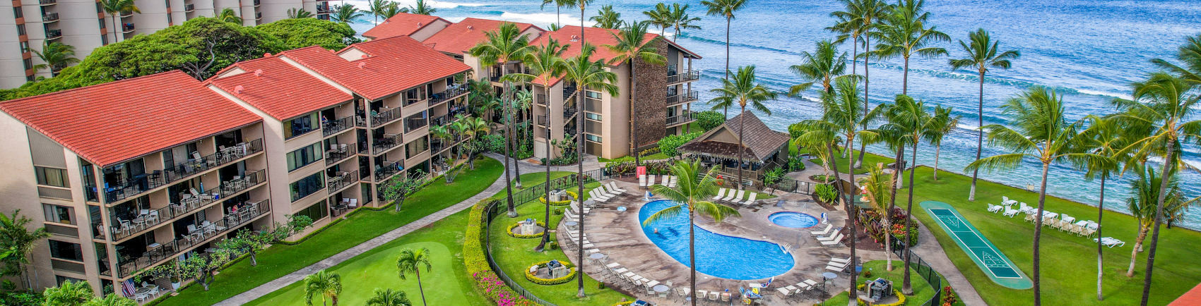 Aston at Papakea Resort Lawn Drone view of pool, palm trees, and ocean