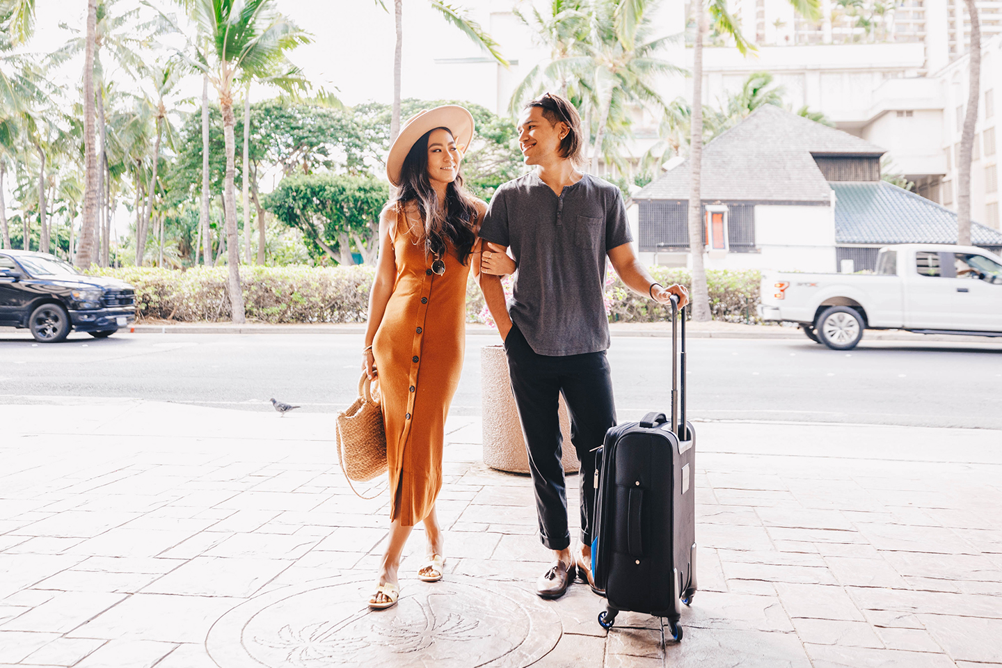 Couple with luggage entering hotel