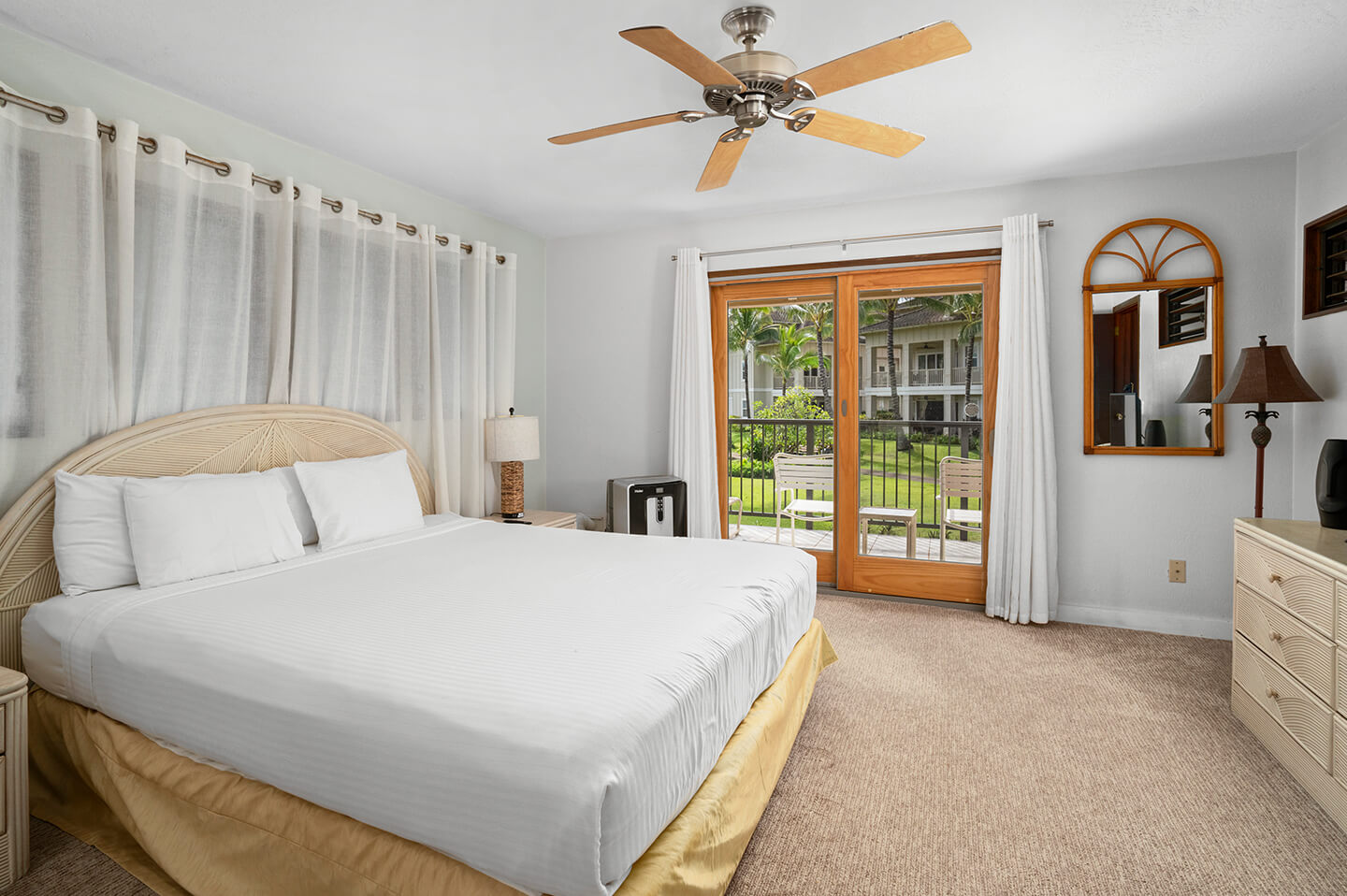 Room with bed, night stand, lamps, large mirriored closets.