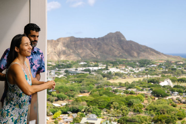Man and woman standing on their private balcony enjoying the views of Diamond Head