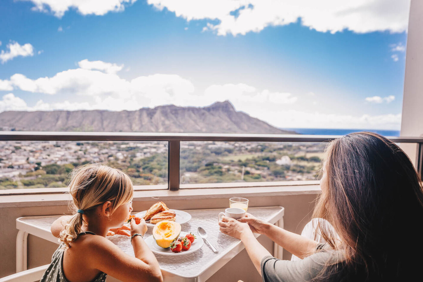 View from One-Bedroom Deluxe Ocean View Lanai with mom and daughter enjoying breakfast on the balcony