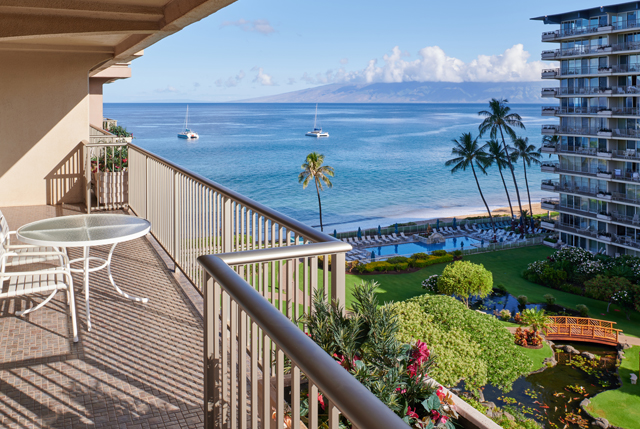 Balcony with chair and table overlooking the ocean.