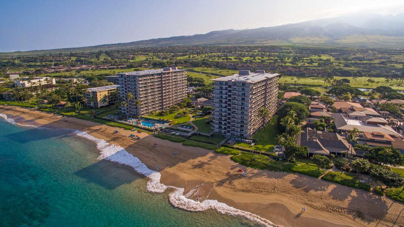 Aerial view of resort, beachfront, ocean, and mountains in the background