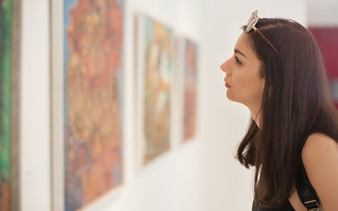 Woman looking at painting in museum
