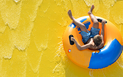 Kid on inflatable tube and water ride feature